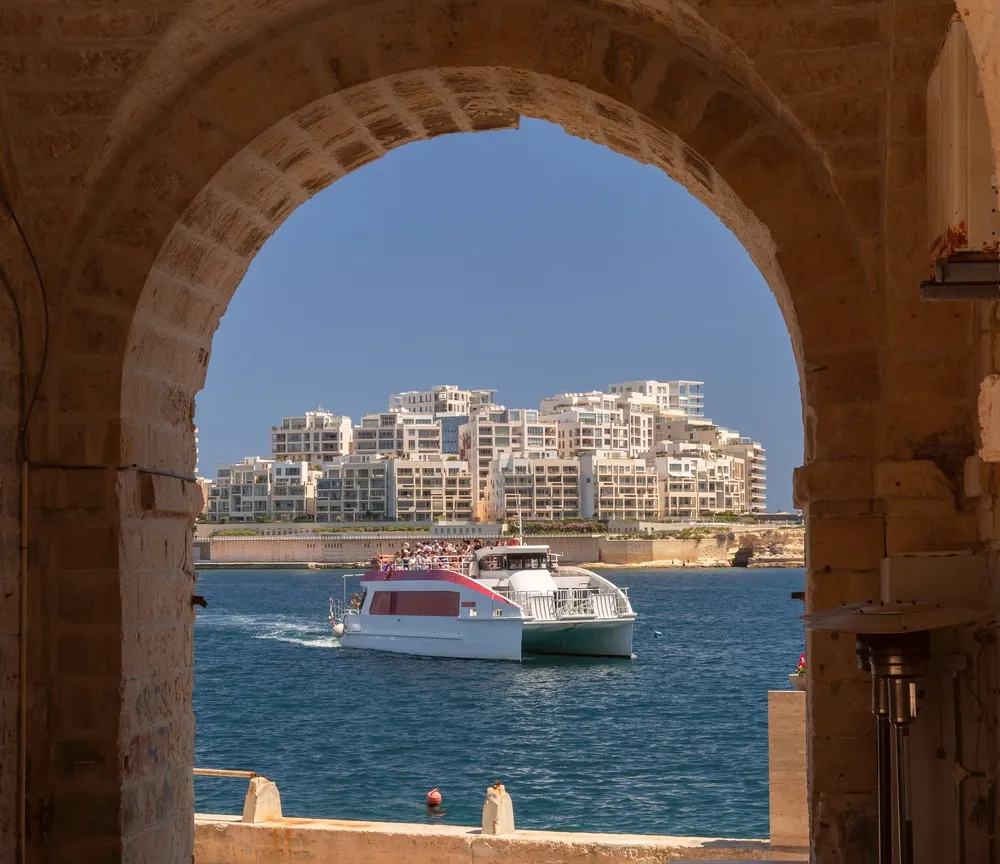 Il traghetto per Sliema attraversa il porto di Marsamxett, incorniciato da un arco di pietra a Valletta
