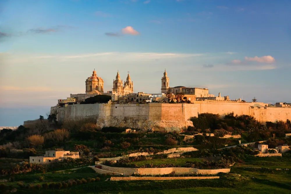 The walls and cathedral dome of Mdina at sunset, seen from Mtarfa