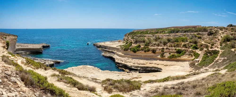 Panorama di St Peter’s Pool e della costa di Delimara con mare turchese e nessuno in acqua